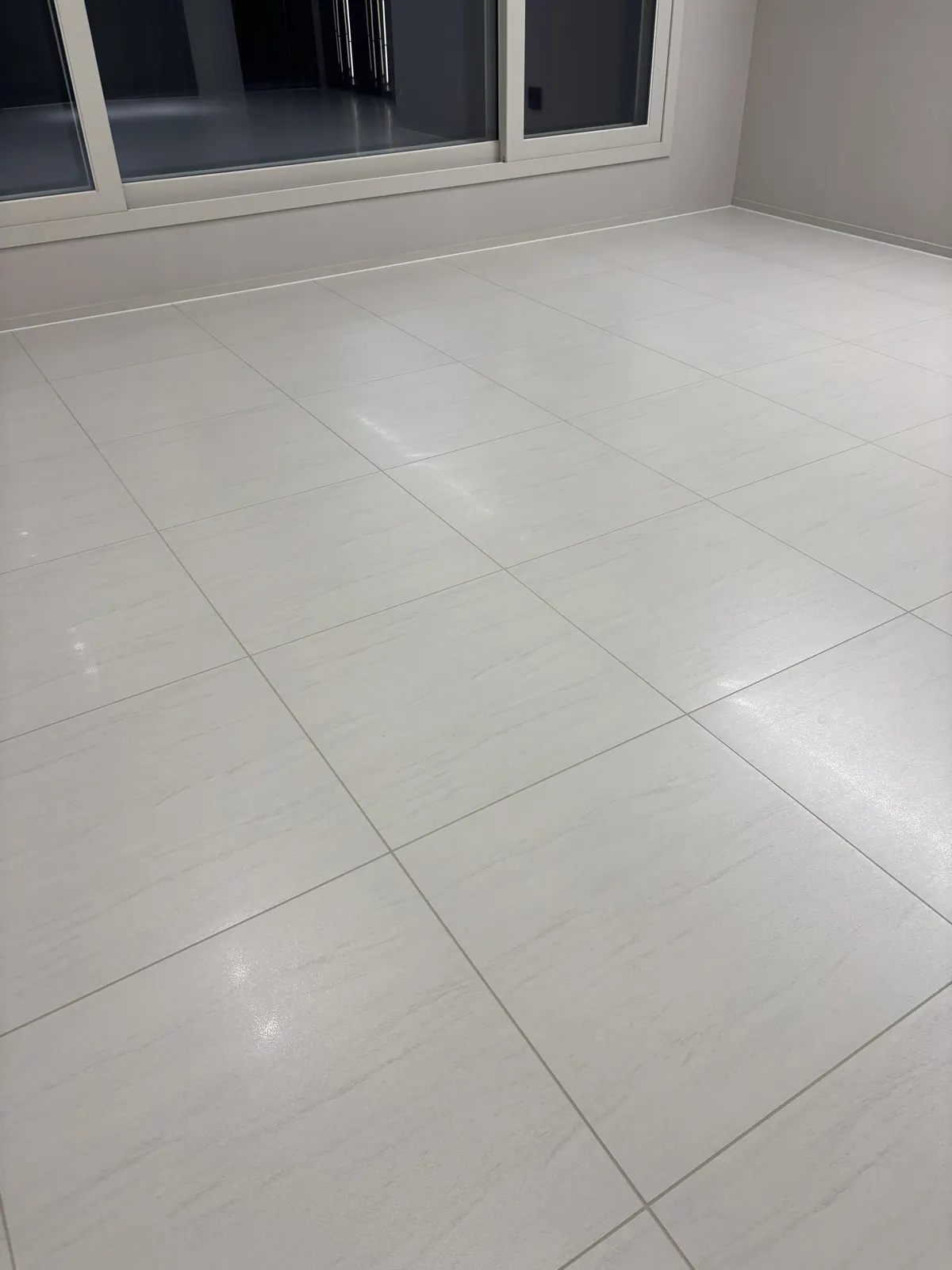 창가까지 이어지는 밝은 대형 타일 거실 바닥 전체