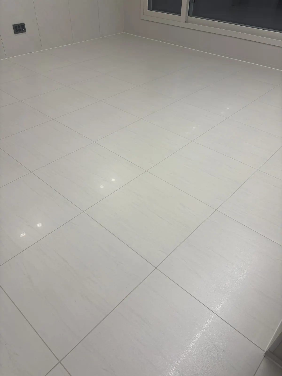 창 아래 걸레받이까지 줄눈 선이 이어진 거실 바닥