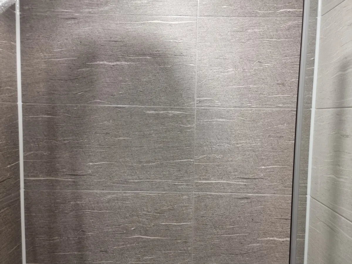 샤워 벽 타일 가로·세로 이음매에 채운 밝은 줄눈